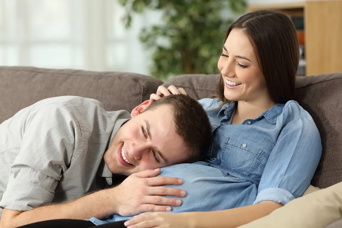 Father hearing his son kicking inside mother belly