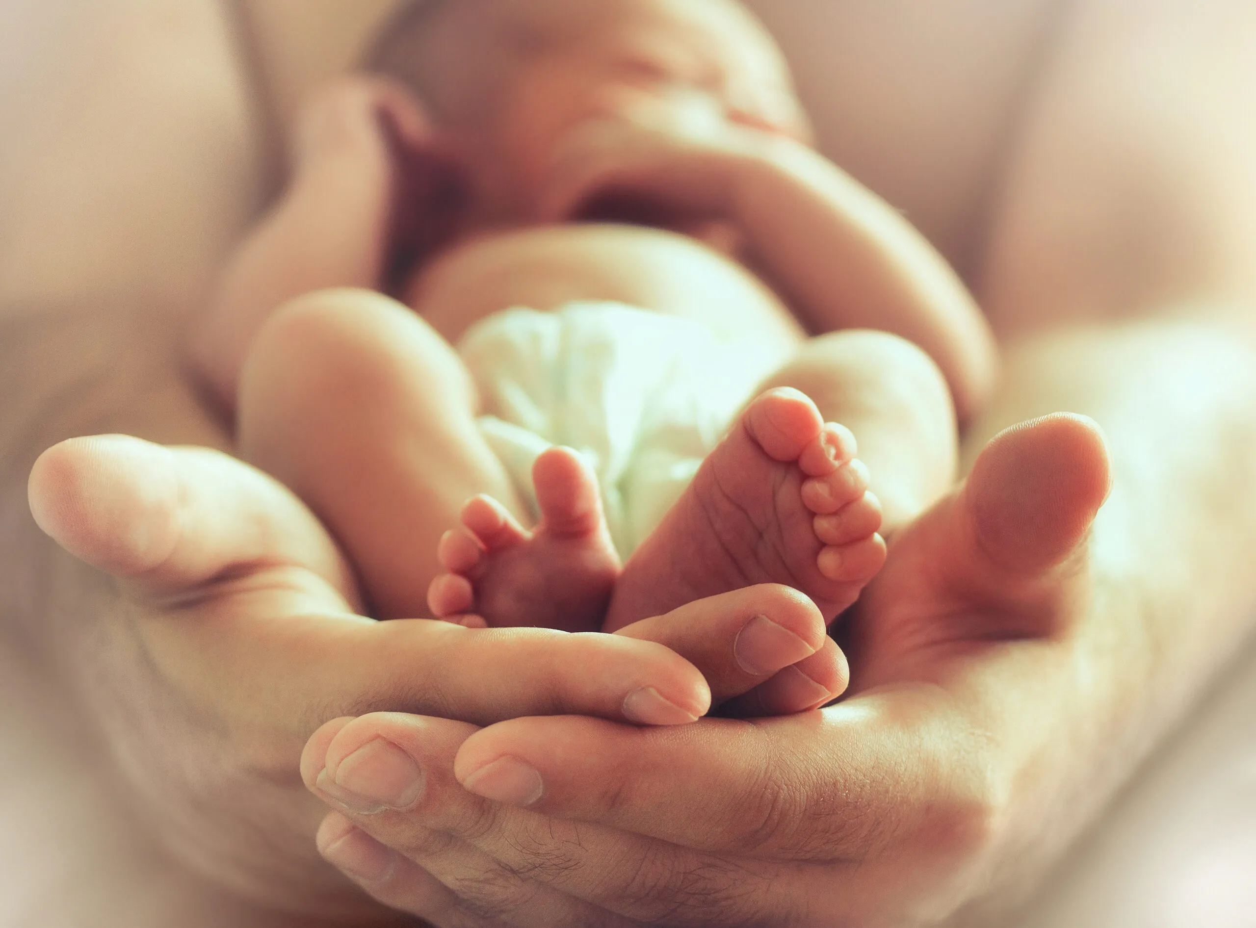 sleeping newborn baby on male hands